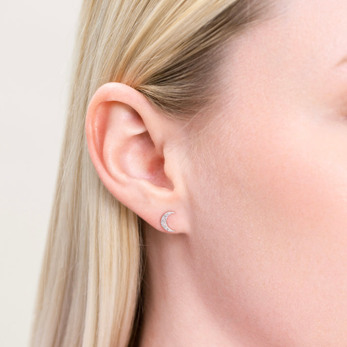 Close-up of a model wearing a Sterling silver and lab diamonds Crescent moon-shaped stud earring .l