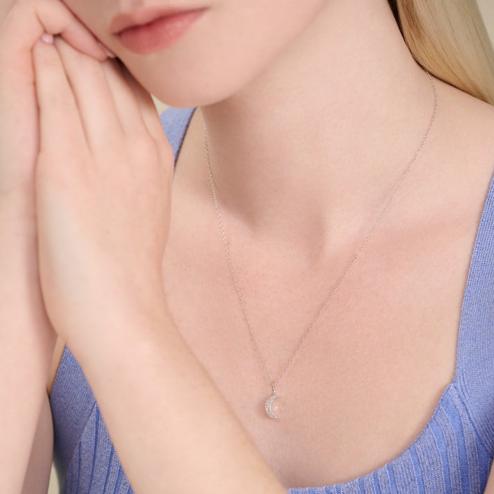 Woman wearing a delicate necklace with a lab diamond crescent moon pendant