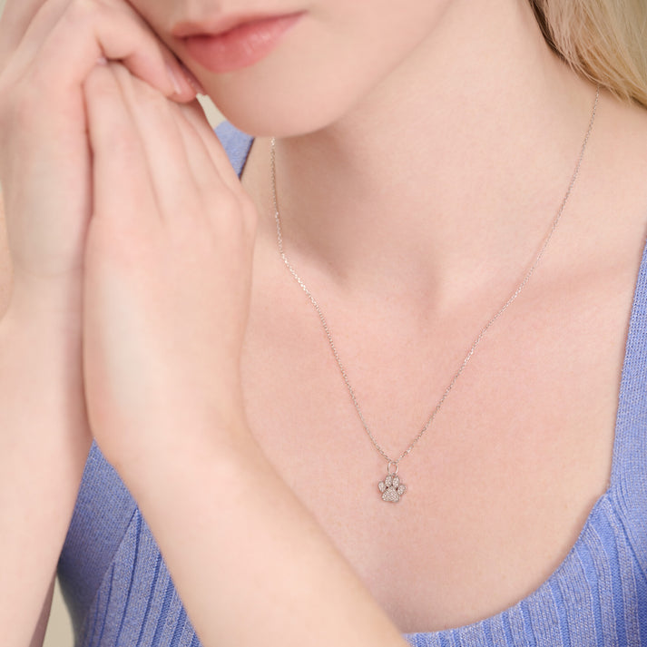 Model wearing a dog paw pendant necklace in rhodium-plated silver with lab diamonds.