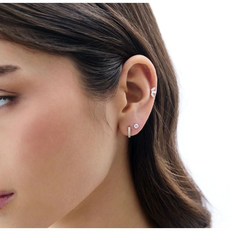 Model wearing a diamond stud and diamond Huggie Hoop earrings 