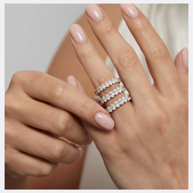 Hand showing a variety of eternity diamond ring styles 