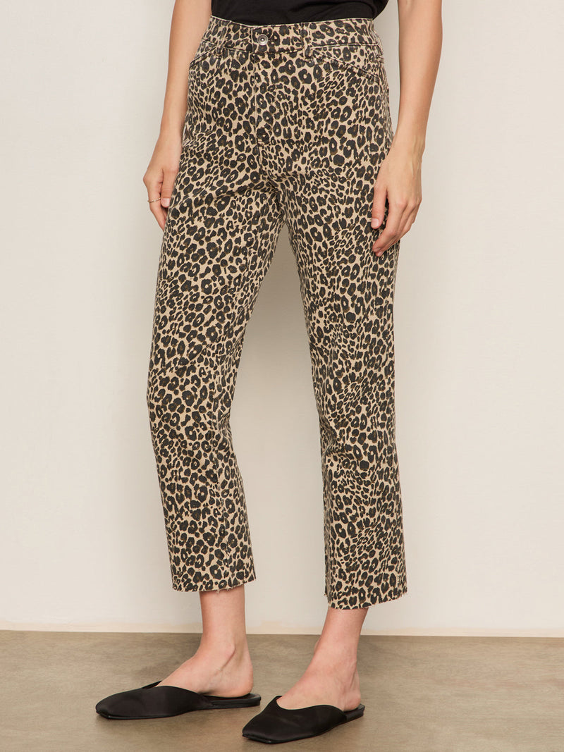Person wearing leopard print pants against a plain background