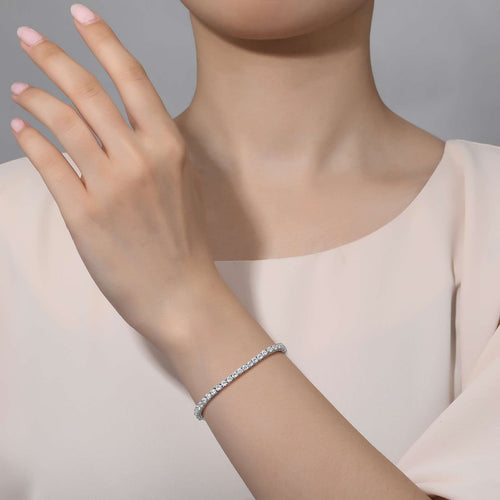 Model wearing  a stunning Classic tennis bracelet 65 Simulated Diamond set in Platinum bonded sterling silver. 