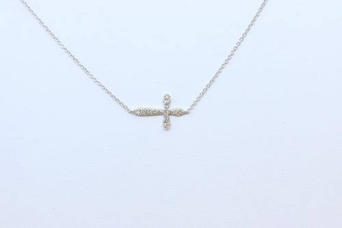 A delicate white gold necklace with a pave diamond sideways cross  