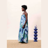 Woman wearing a blue floral dress - Blue waterlily - a maxi strapped sundress crafted   n a cotton silk blend material. 