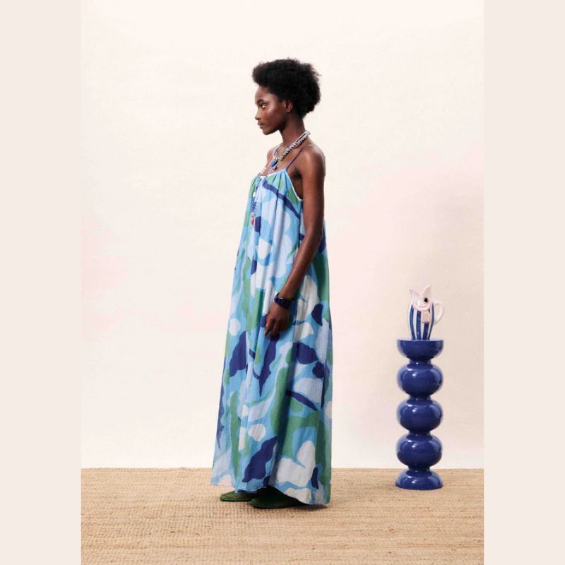 Woman wearing a blue floral dress - Blue waterlily - a maxi strapped sundress crafted   n a cotton silk blend material. 