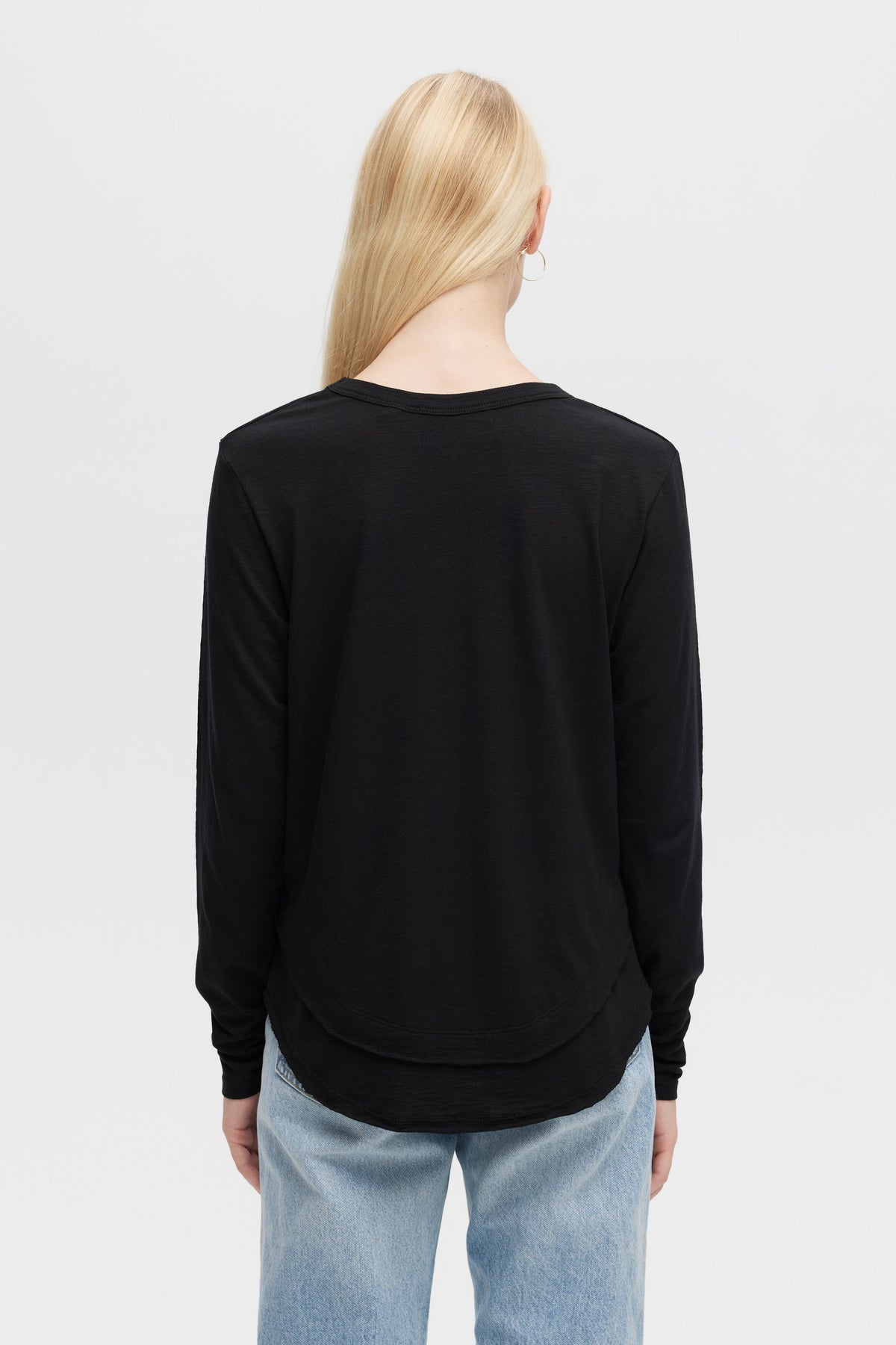 Model wearing Ava long sleeve top in black with hemline detail- Vack view 