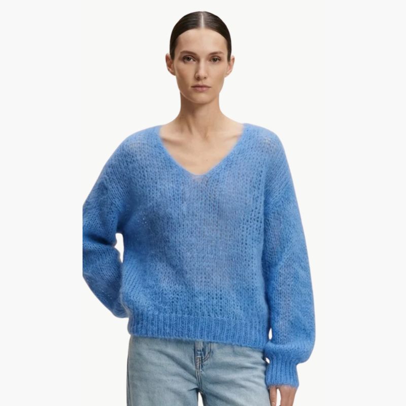 An iconic v neck mohair pullover sweater in a vivid sky blue on model 