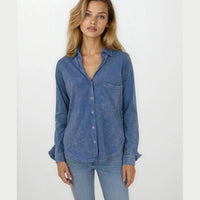 Woman wearing a Pima cotton long-sleeve denim blue shirt and jeans on a white background
