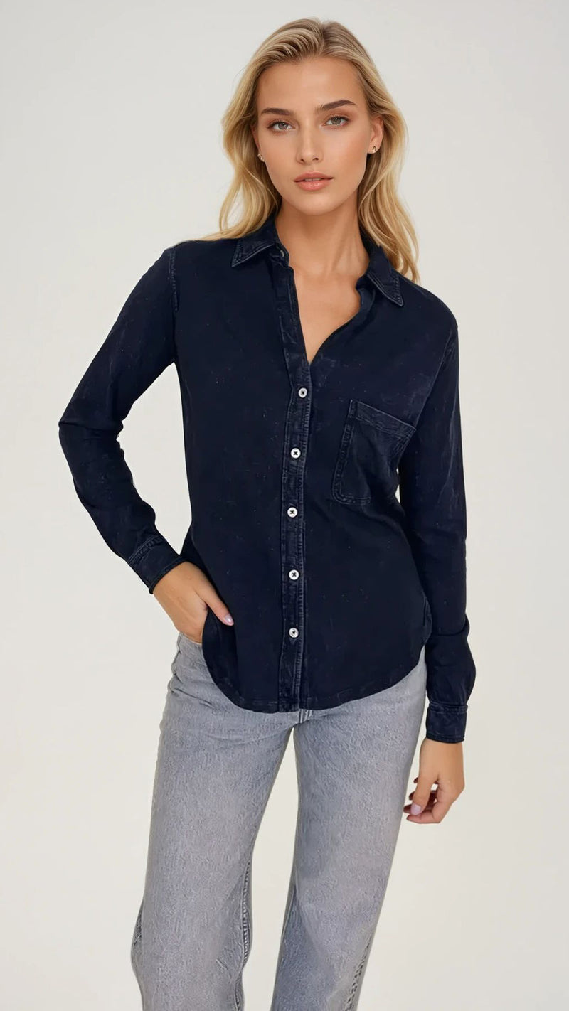 Woman wearing a dark indigo sub- jersey AMRAT button-up shirt with light blue jeans. 