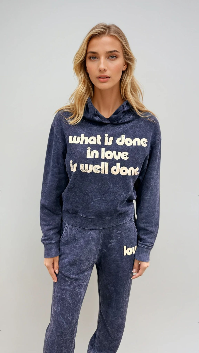 Woman wearing the Inidgo Hoodie and P.E. Sweatpants by CHRLDR. Front graphic on hoodie reads 'What's Done is Done! 