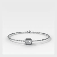 A delicate white Gold chain bracelet featuring a central rectangular emerald-cut clear gemstone in a prong setting, displayed on a clean light gray background.