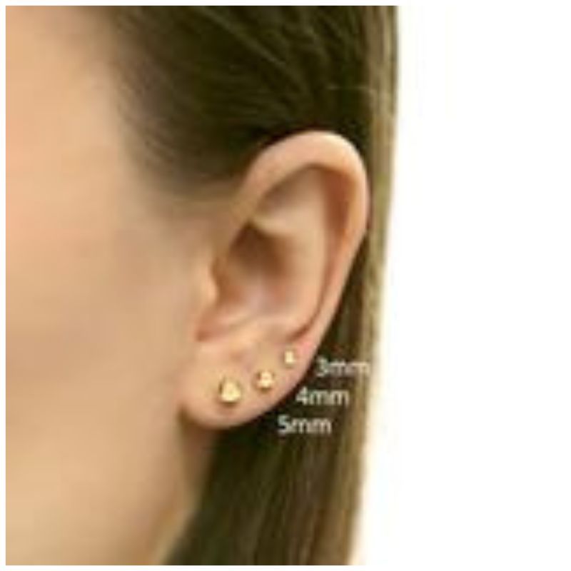 Gold earrings on an ear with size measurements indicated.