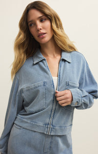 A woman wearing a light blue French Terry denim jacket against a plain background