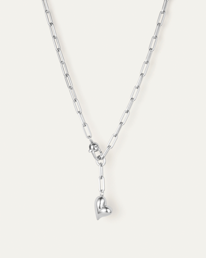 Silver chain necklace with a heart pendant on a white background