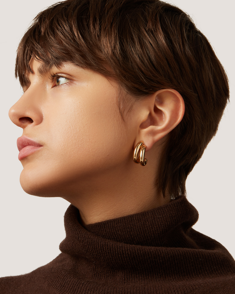 Side view of model wearing The Florence Earring in Gol high Polish  Gold- showing the illusion of wearing 2 hoops stacked together. 