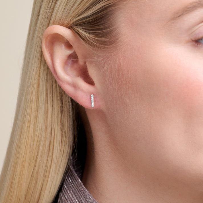 Close-up of a model wearing Lab diamond bar earrings set in rhodium plated sterling silver 