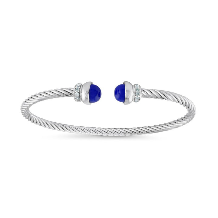 A silver cable-wrapped twist bangle bracelet with two oval deep blue gemstone accents on the ends, set against a plain white background.