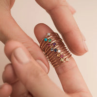 Model wearing several Rings in gold with stones.- Featured is the gold and Turquoise 