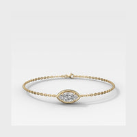 A delicate gold chain bracelet with an oval bezel-set diamond centerpiece, displayed on a clean white background.