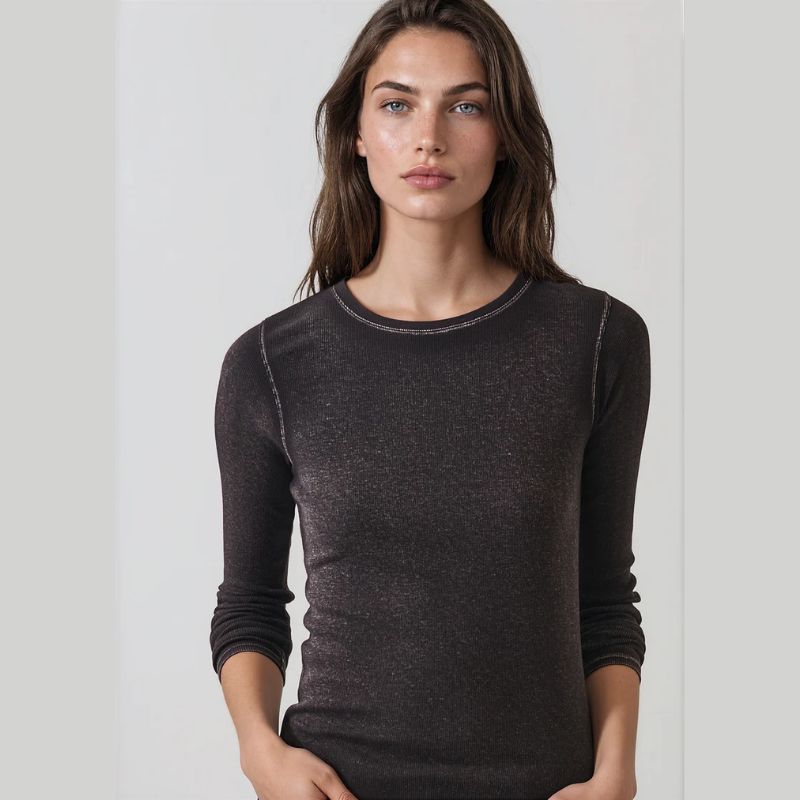 A woman wearing a dark brown long-sleeve crewneck knit top, photographed against a clean light gray studio background.