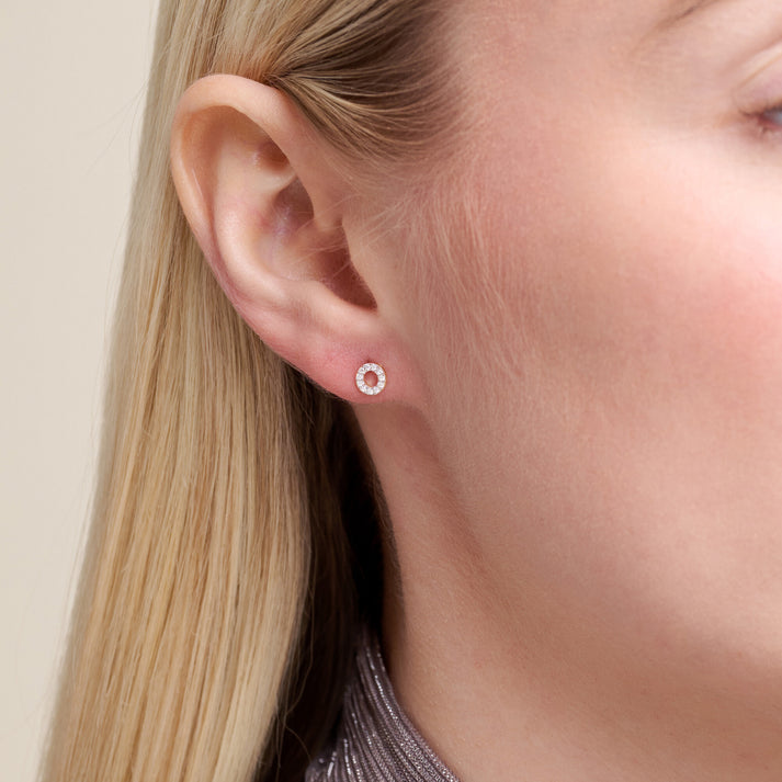 Close-up of a model wearing a diamond circle stud earring 
