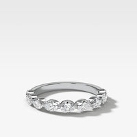White gold oval diamond eternity ring with embedded oval diamonds set east west  on a light gray background