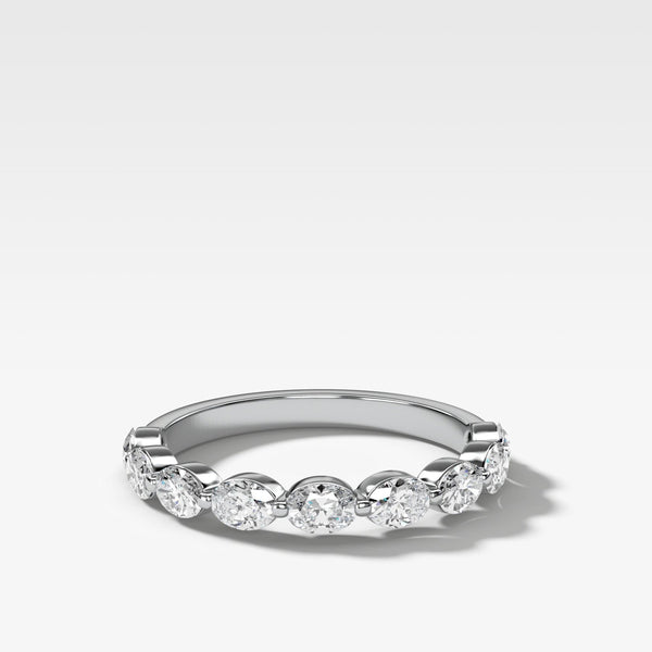 White gold oval diamond eternity ring with embedded oval diamonds set east west  on a light gray background