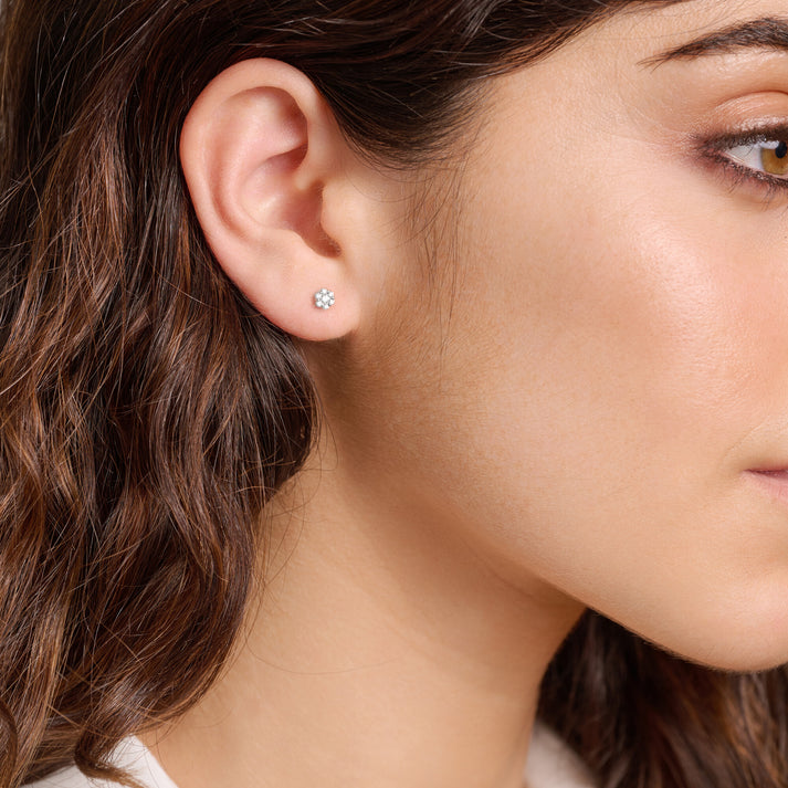 Close-up of a woman wearing a fLab diamond floral cluster stud earring.
