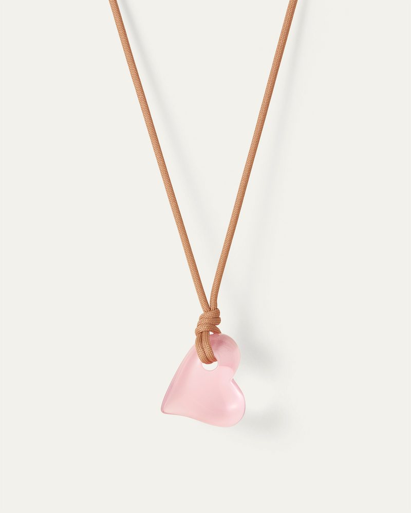 Jenny Bird large pink Glass Heart hanging on a sand colored cord. full view 