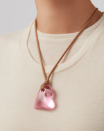 Model wearing pink recycled glass pendent on a sand string cord  by jenny Bird.