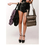 Model carrying both of the Vegan leather puffer totes by FREED  in Black and in Bronze. Totes are Nade in Canada 