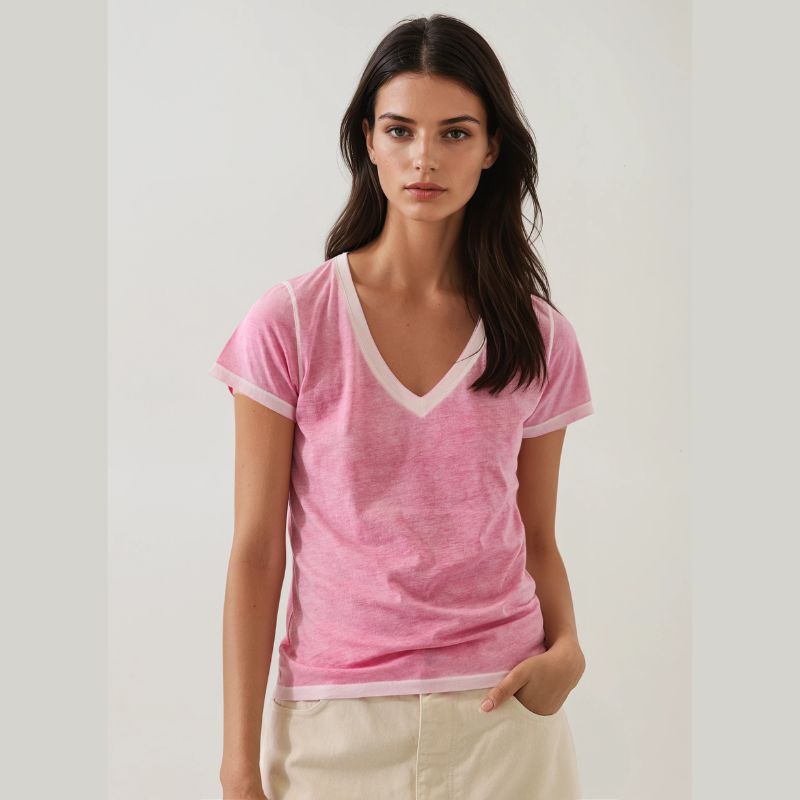Woman wearing a pink t-shirt with white trim on a plain background