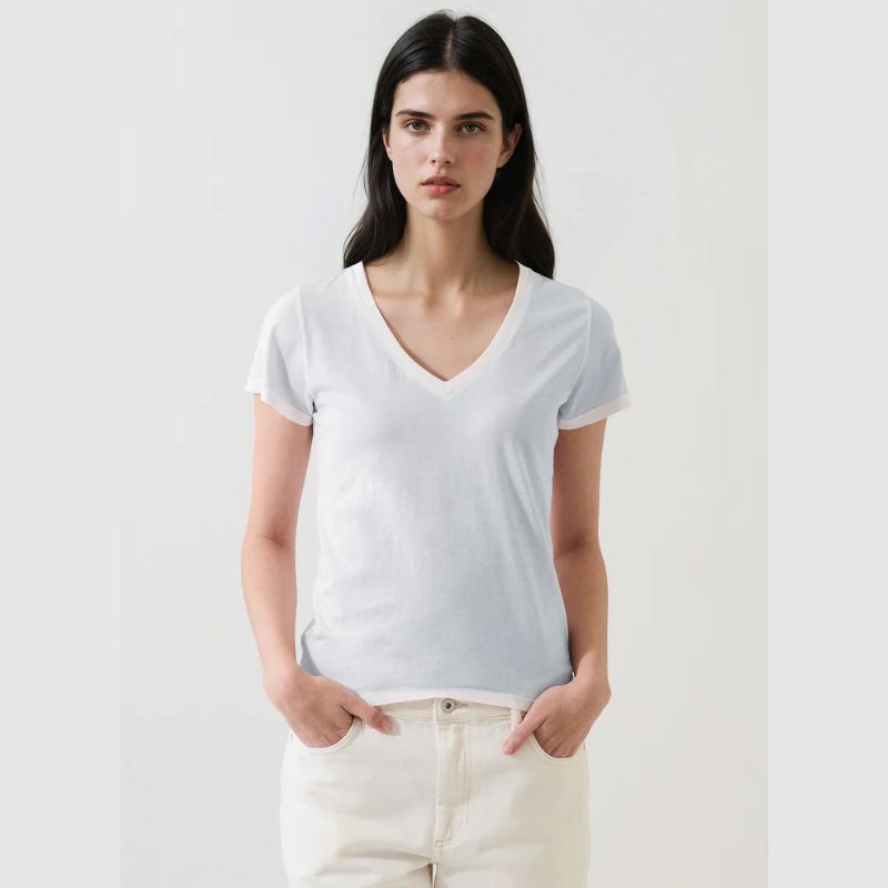 Woman wearing a very pale blue t-shirt against a light gray background