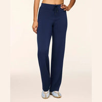 A model wearing navy blue drawstring sweatpants and light blue sneakers, shown from the waist down against a plain beige studio background.