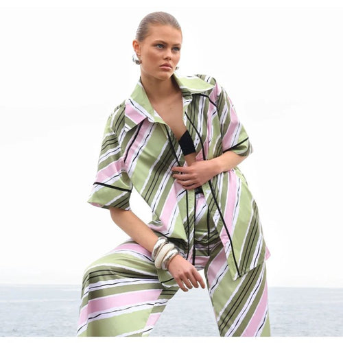 Pink and green satin button up shirt with contrast green piping down the front and on sleeve .