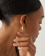 Teeni Toni Huggie Earrings in gold on Model 