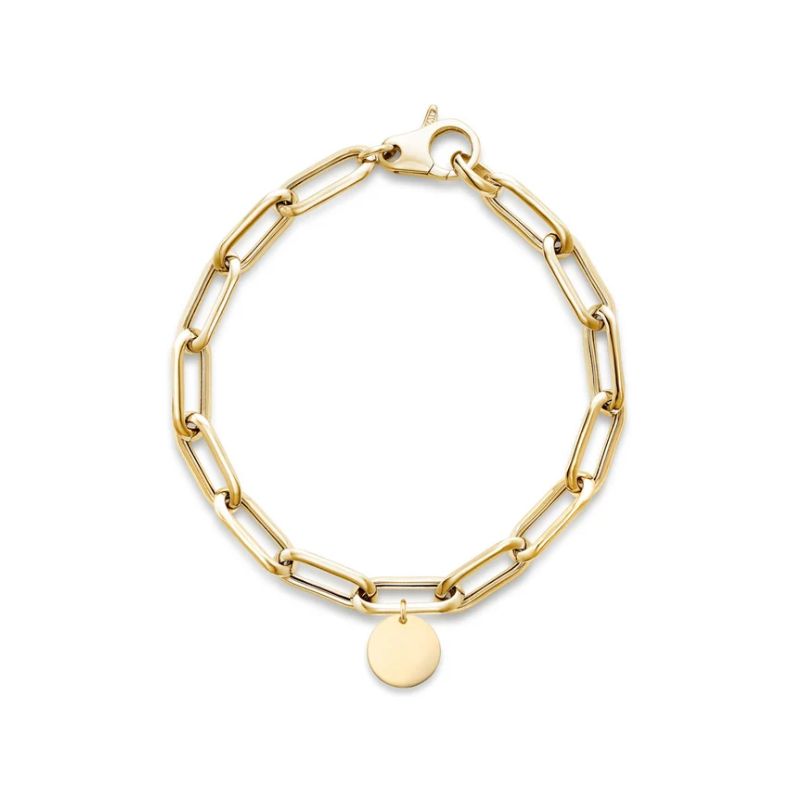 A gold paperclip chain bracelet with a small, flat circular disc charm, displayed on a clean white background.