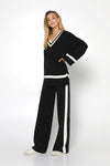 varsity knit sweater in black with ivory white trim  at neckline, cuff and hem 