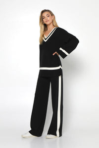 varsity knit sweater in black with ivory white trim  at neckline, cuff and hem 