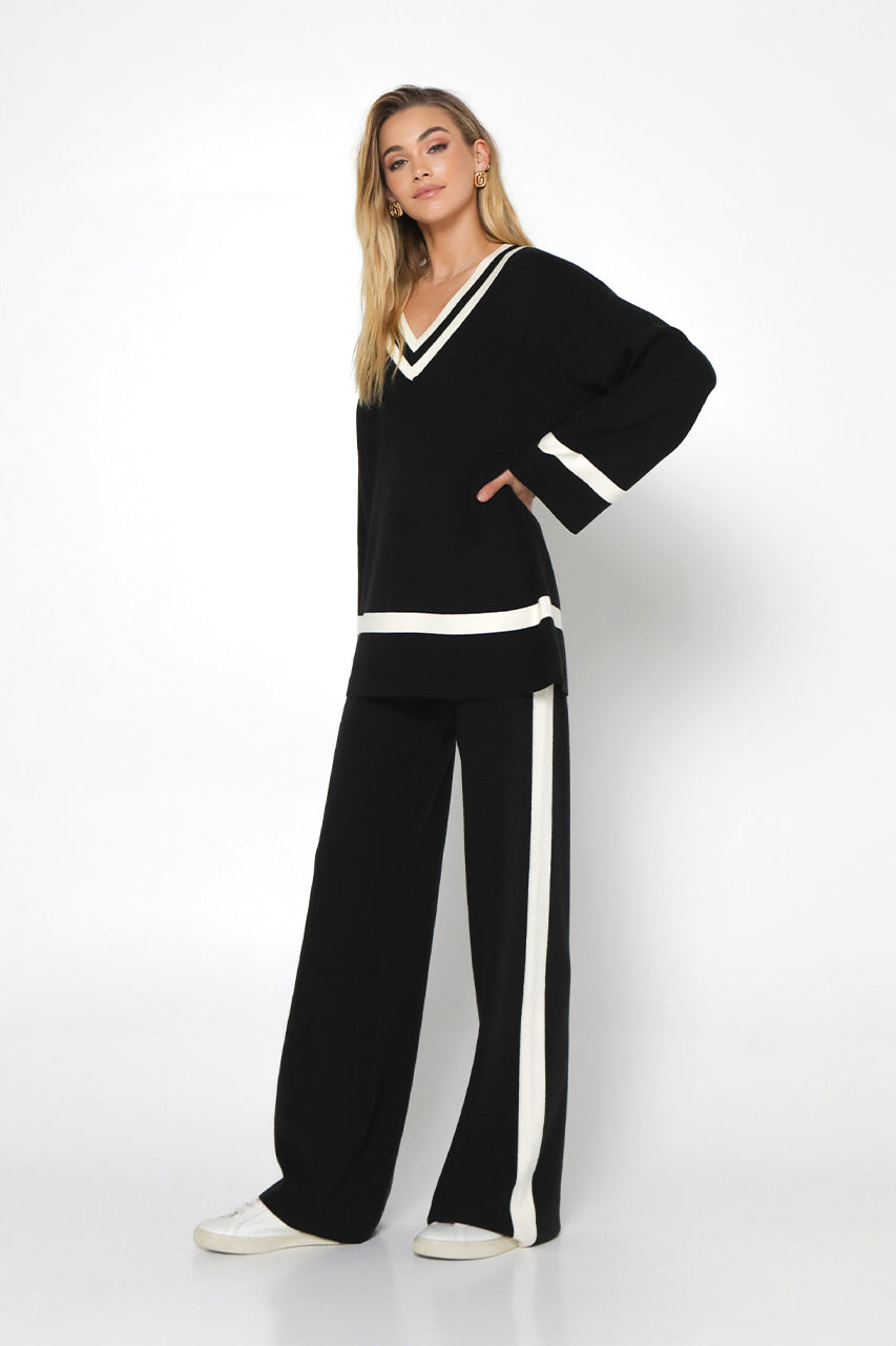 varsity knit sweater in black with ivory white trim  at neckline, cuff and hem 