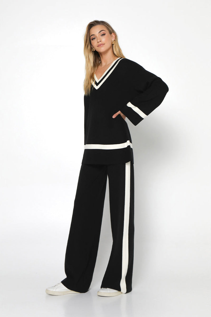 varsity knit sweater in black with ivory white trim  at neckline, cuff and hem 