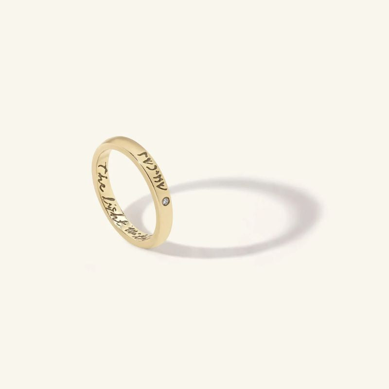 Yellow old ring with engraved text on a white background 