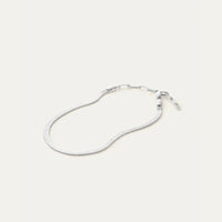 Silver snake chain anklet on a light gray background