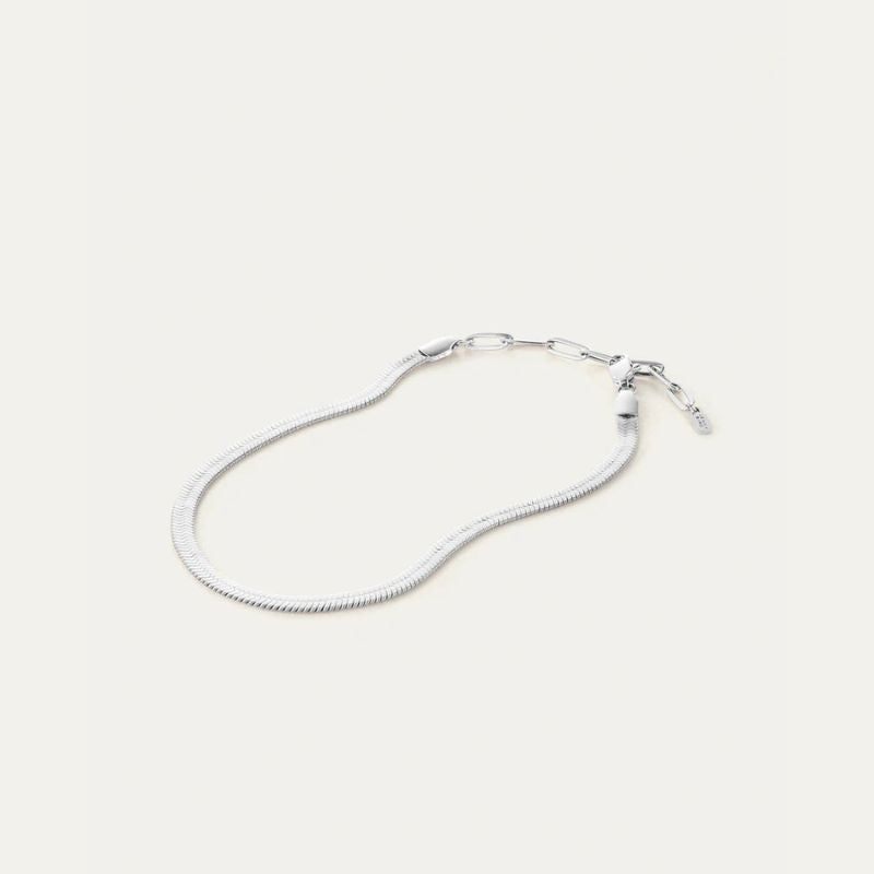 Silver snake chain anklet on a light gray background