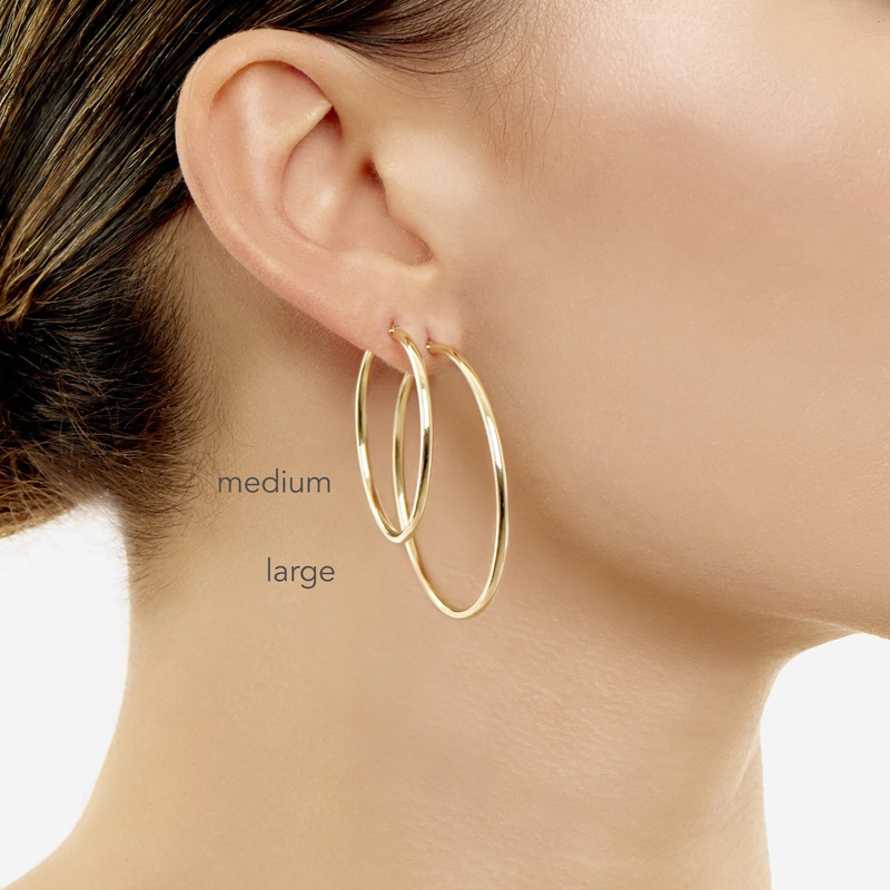 2mm Gold Tube Hoops model wearing  medium on top and a largeon bottom. 