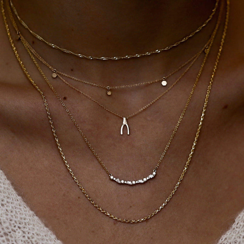 Everyday Little Wishbone Necklace worn by model with 2 other Gold necklaces. 