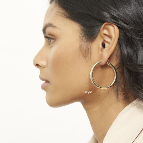 Model wearing a large pair of 4mm goad tube  hoops 