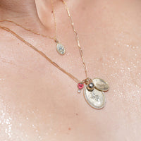 Model wearing a complement of ZAHAVA Pendant necklaces including the Pink Tourmaline /Diamond Heart Reversible Charm