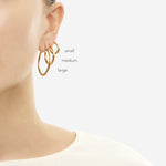 Model wearing small, medium, and large 3mm gold tube hoops